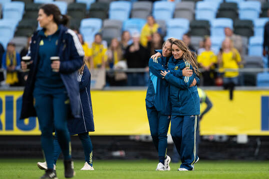 Assistant coach Johanna Almgren and Kosovare Asllani of