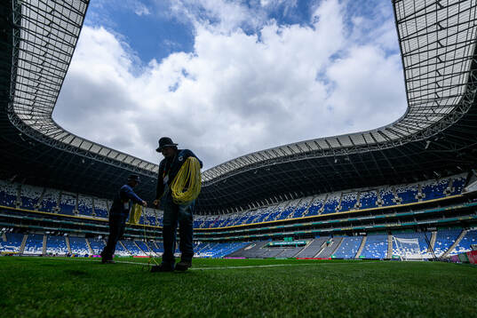 Workers prepare the pitch