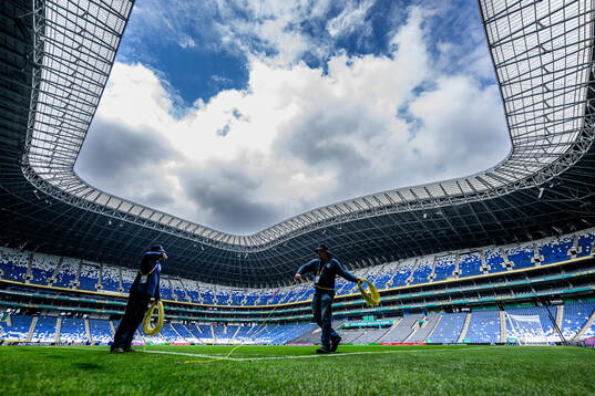 Workers prepare the pitch