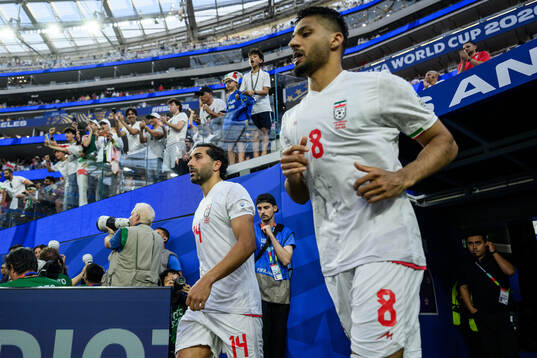 Saman Ghoddos and Mohammad Mohebbi of Iran enter the pitch