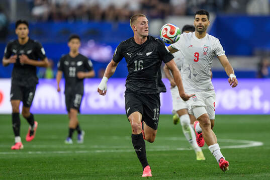 Finn Surman of New Zealand and Mehdi Taremi of Iran