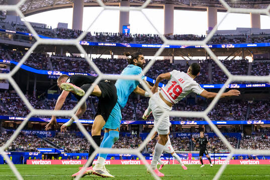 Finn Surman of New Zealand in action against goalkeeper