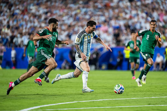 Rayan Ait-Nouri of Algeria and Lionel Messi of Argentina