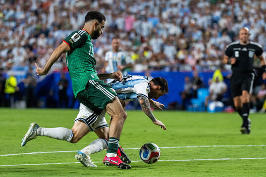 Rayan Ait-Nouri of Algeria and Lionel Messi of Argentina