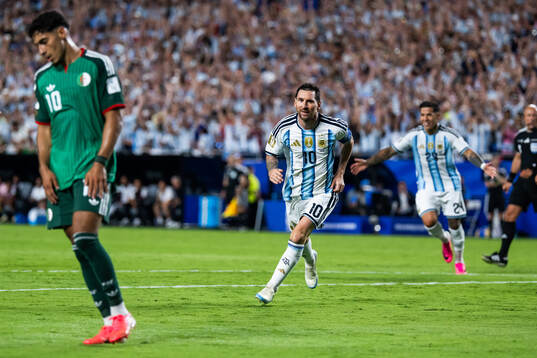 Fares Chaibi of Algeria looks dejected and Lionel Messi and