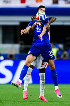 Ezri Konsa of England and Petar Musa of Croatia