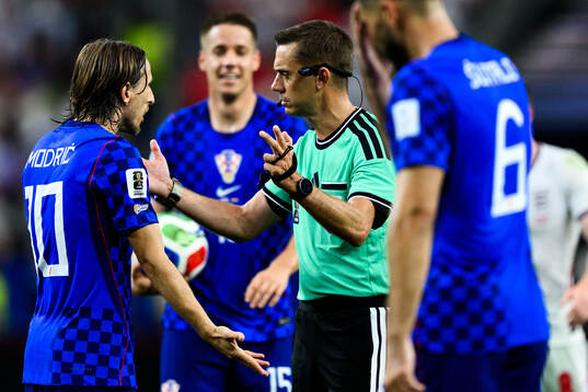 Luka Modric of Croatia and Referee Clement Turpin