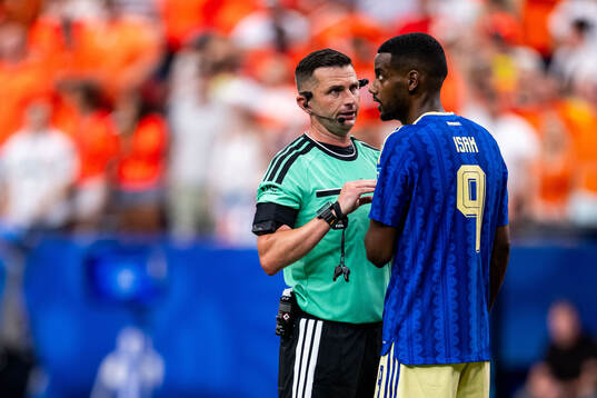 Referee Michael Oliver and Alexander Isak of Sweden
