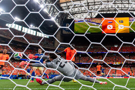 Brian Brobbey of Netherlands scores 1-0 behind goalkeeper