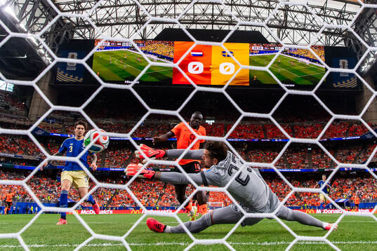 Brian Brobbey of Netherlands scores 1-0 behind goalkeeper