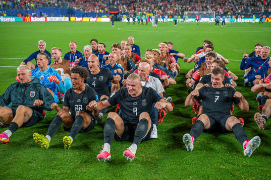 Players and staff of Norway celebrate with a viking row
