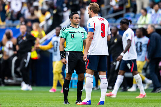 Referee Said Martinez and Harry Kane of England
