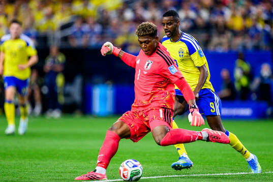 Goalkeeper Zion Suzuki of Japan and Alexander Isak of Sweden
