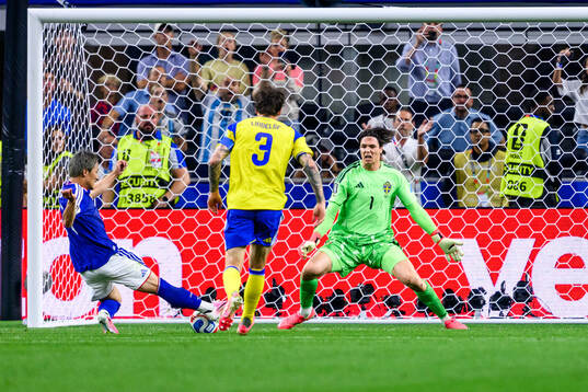 Daizen Maeda of Japan and goalkeeper Jacob Widell