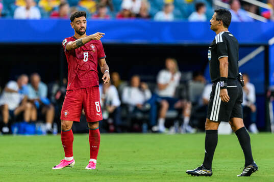 Bruno Fernandes of Portugal and Referee Alireza Faghani