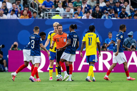Referee Danny Makkelie with Michael Olise and Lucas Digne