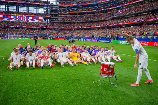 Players and staff of Norway celebrate with a viking row