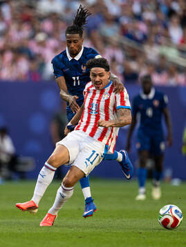Michael Olise of France and Mauricio of Paraguay