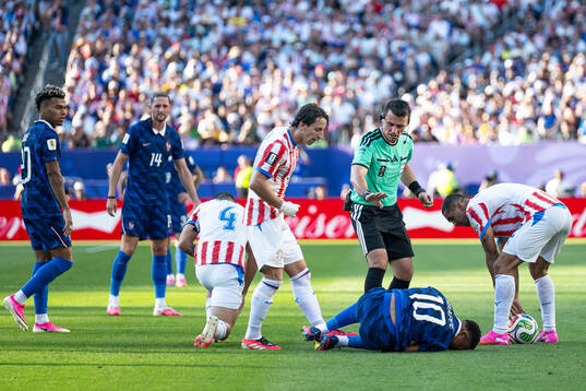 Referee Ilgiz Tantashev and Kylian Mbappe of France