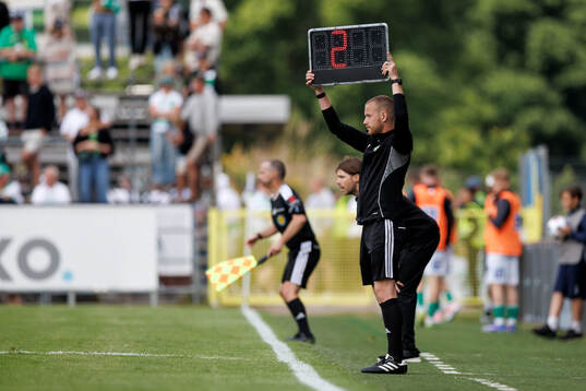 Fjärde domare Fredrik Karlsson visar upp tilläggstiden