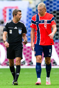 Referee Clément Turpin and Erling Braut Haaland of Norway