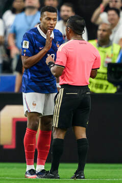 Kylian Mbappe of France and Referee Ivan Barton