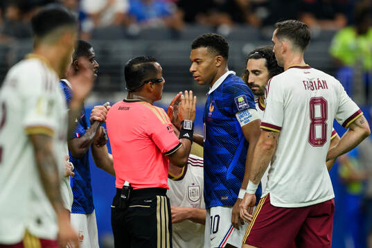 Referee Ivan Barton and Kylian Mbappe of France