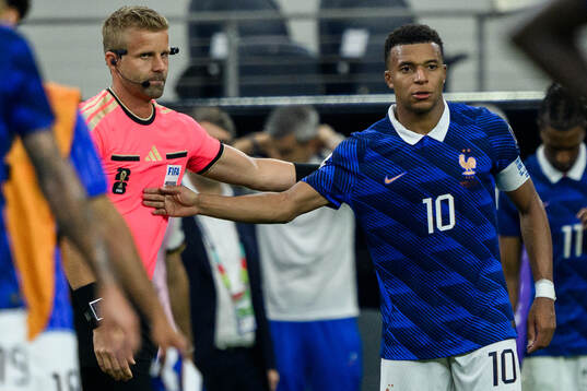 Assistant refere Glenn Nyberg and Kylian Mbappe of France
