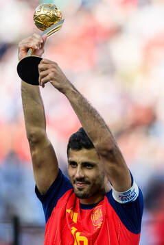 Rodri of Spain hoists his award for MVP of the tournament