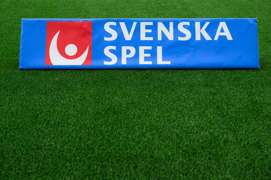 En skylt med Svenska Spel på konstgräs