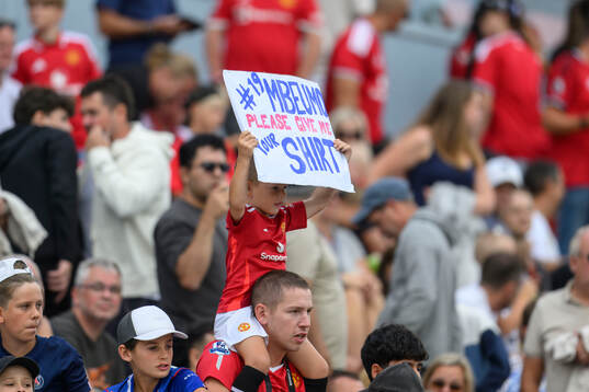 a young Manchester United fan with a sign