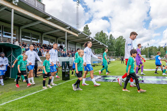 Oddevolds och Ljungskiles spelare marscherar in