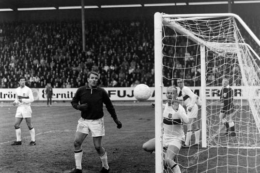 Bollen på väg in i mål bakom Leif Andersson, målvakt i