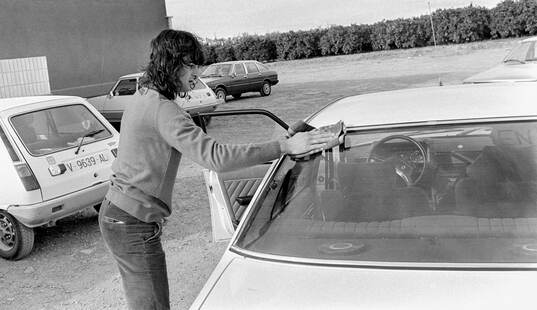 Mario Kempes wipes the windows of his car