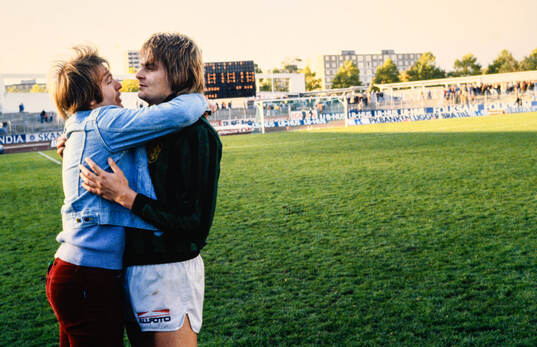 En GAIS-spelare kramas med en supporter