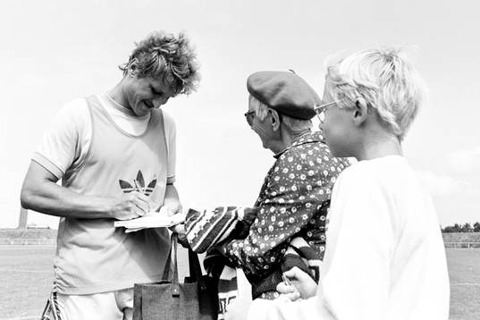 Thomas Larsson skriver en autograf till en äldre dam