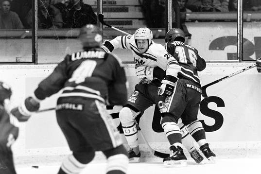 Sveriges Bo Berglund trycks upp i sargen av Jukka Virtanen,