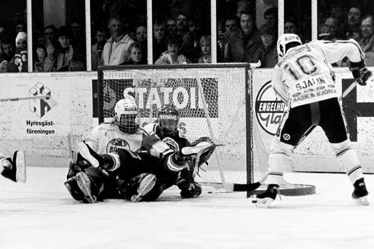 Rögles Tommy Själin med pucken framför Billy Nilsson,