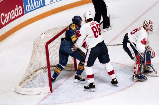 Kanadas Eric Lindros håller undan en svensk spelare