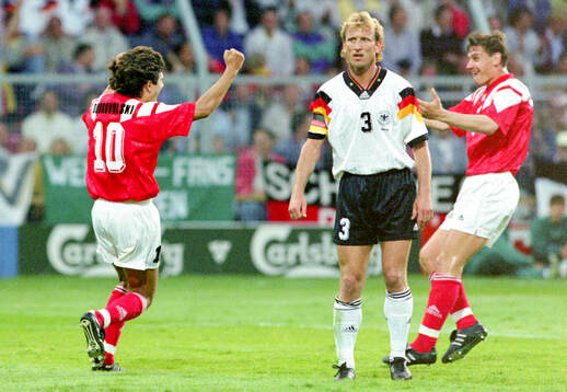 Igor Dobrovolskiy of CIS (L) celebrates his 1-0 goal with