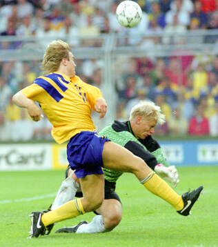 Swedens Tomas Brolin against Denmarks goalkeeper Peter