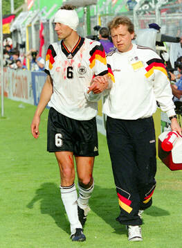 Germanys Guido Buchwald is helped off the pitch