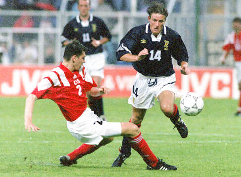 Andrey Chernyshov of CIS tackles Kevin Gallacher of Scotland