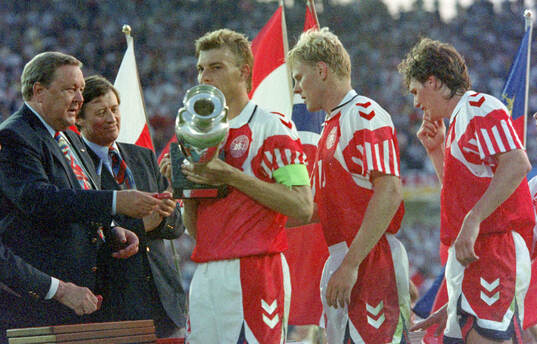 Denmarks captain Lars Olsen receives the trophy from UEFA