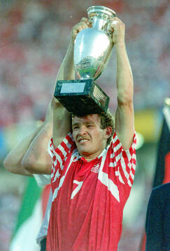 Denmarks John Jensen celebrates with the trophy