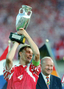 Denmarks captain Lars Olsen celebrates with the trophy