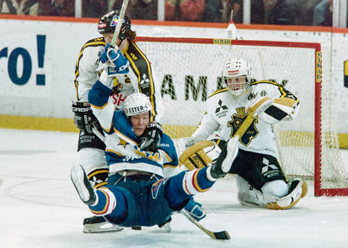 Peter Eriksson, HV71 dras omkull framför Rolf Ridderwall,