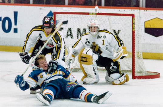 Peter Eriksson, HV71 dras omkull framför Rolf Ridderwall,
