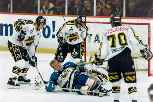 Peter Eriksson, HV71 dras omkull framför Rolf Ridderwall,
