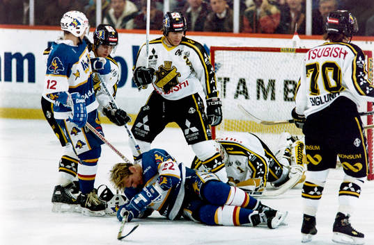 Peter Eriksson, HV71 dras omkull framför Rolf Ridderwall,
